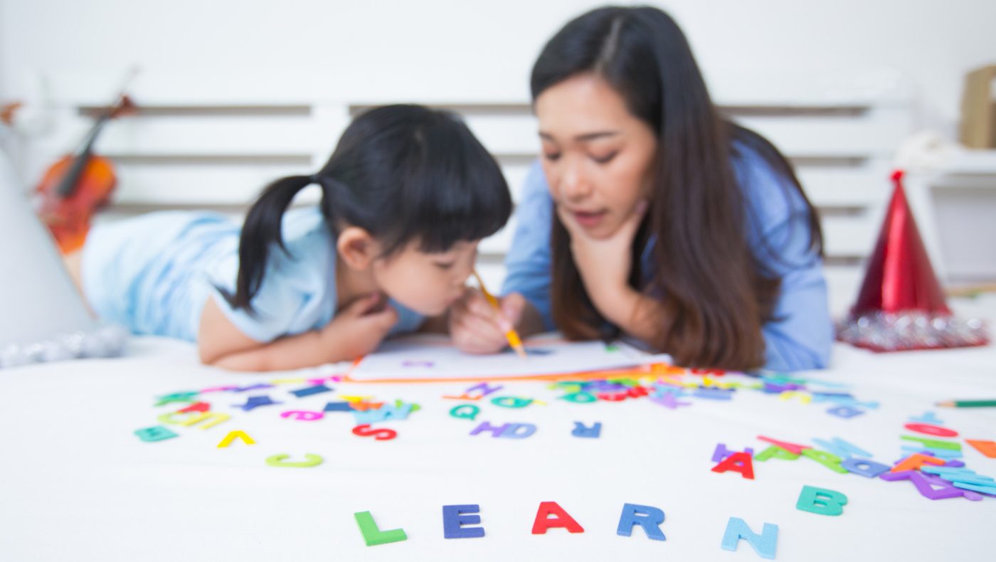 mom teaching daughter to read