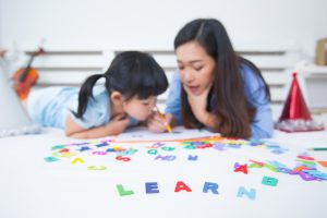 mom teaching daughter to read